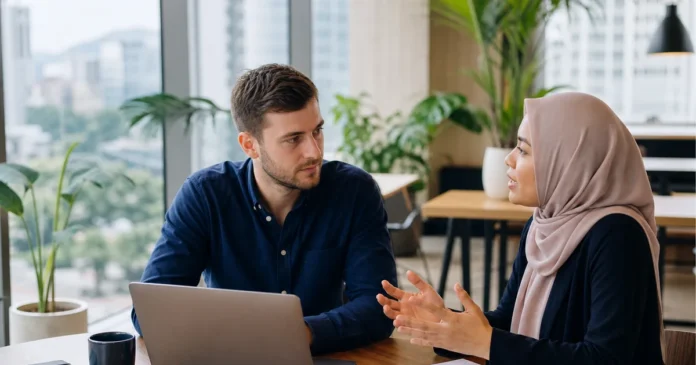Foreign freelancer consulting a Malaysian business adviser in a Kuala Lumpur coworking space