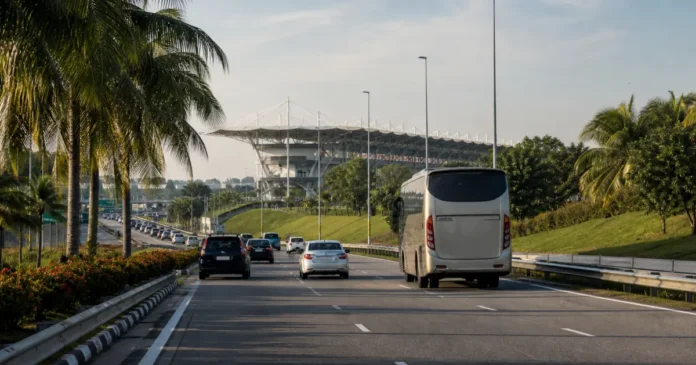 Shuttle bus and cars approaching Sepang International Circuit on a tropical road